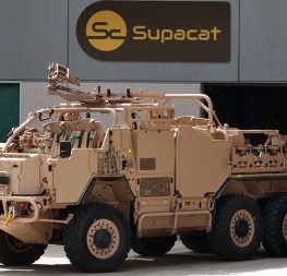 Obrněnec HMT Supacat Extenda 6×6 zaparkovaný před budovou s logem výrobce