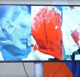 Fotografie oděvu Roberta Fica po atentátu: prostřelené sako a zakrvácené oblečení prezentované během tiskové konference.