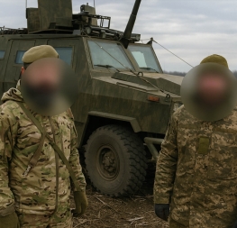 Nábor českých žoldáků na Ukrajině – dva vojáci v maskovacích uniformách před obrněným vozidlem