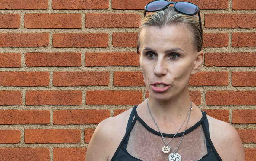 Petra Rédová při rozhovoru o hnutí Stačilo! před cihlovou zdí